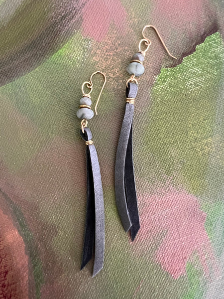 wire wrapped slate grey leather tassel earrings that dangle from a beaded stack